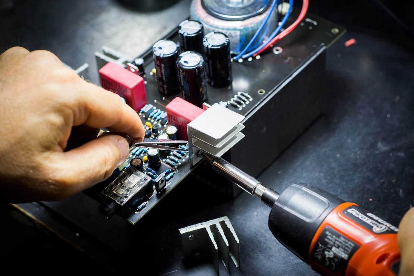 Technician servicing a circuit board with precision tools